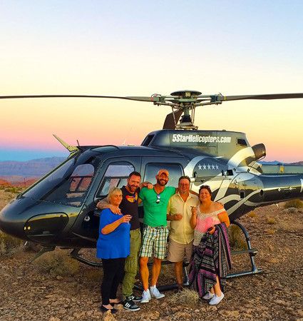 Group beside the helicopter at the Valley of Fire overlook at sunset